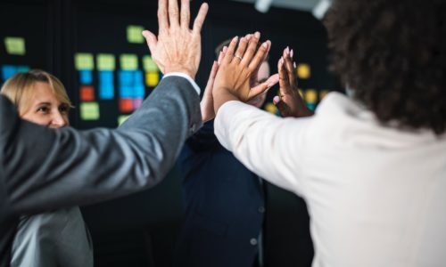 A group of people joining hands in achievement