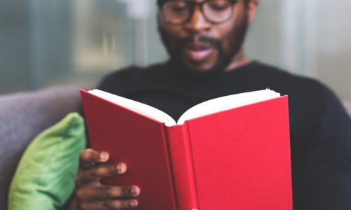 Man with glasses reading a book