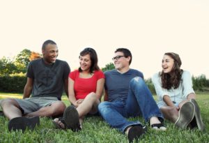 smiling people sitting on the grass