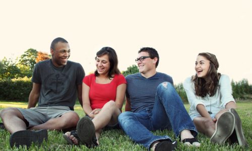 smiling people sitting on the grass