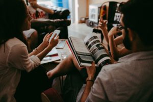 A group pf people meeting, with books and smartphones