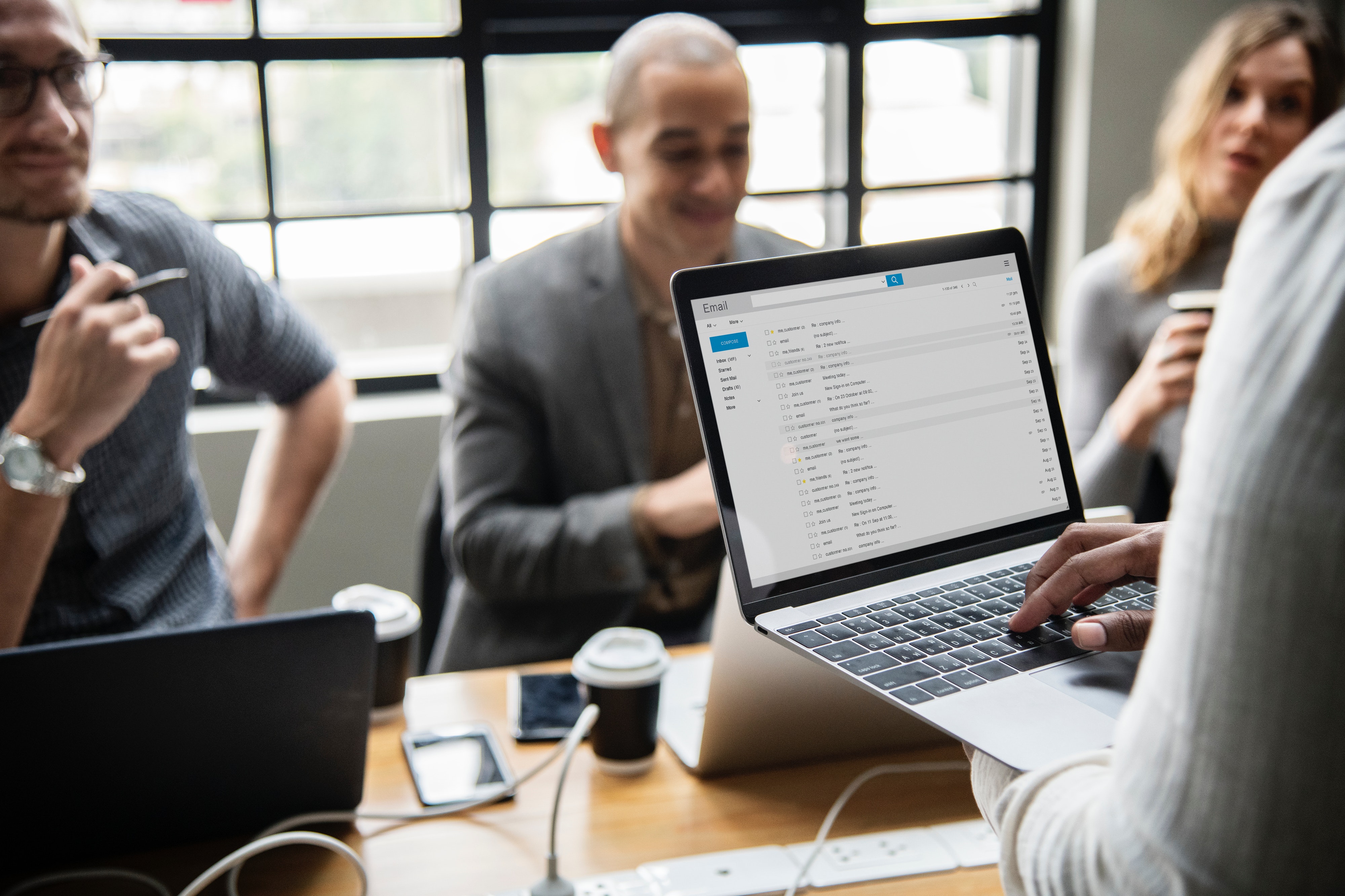 Four people discussing a topic with a laptop.